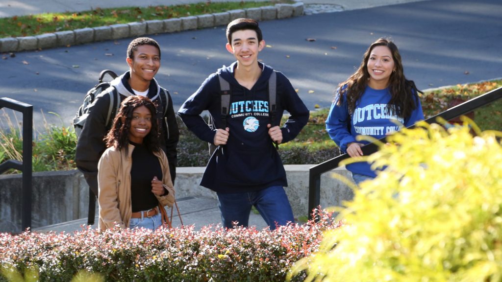 Students on campus smiling at camera