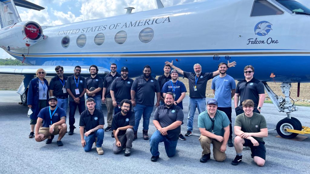 Aviation class in front of a plane